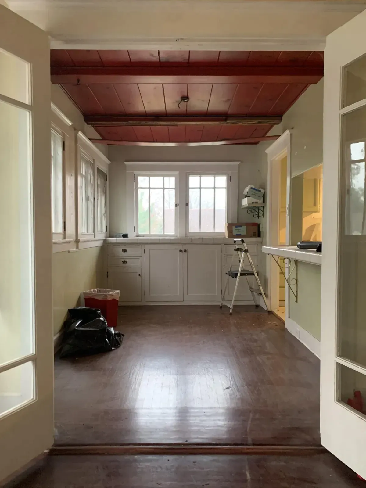 An empty room with a wooden floor and a red ceiling