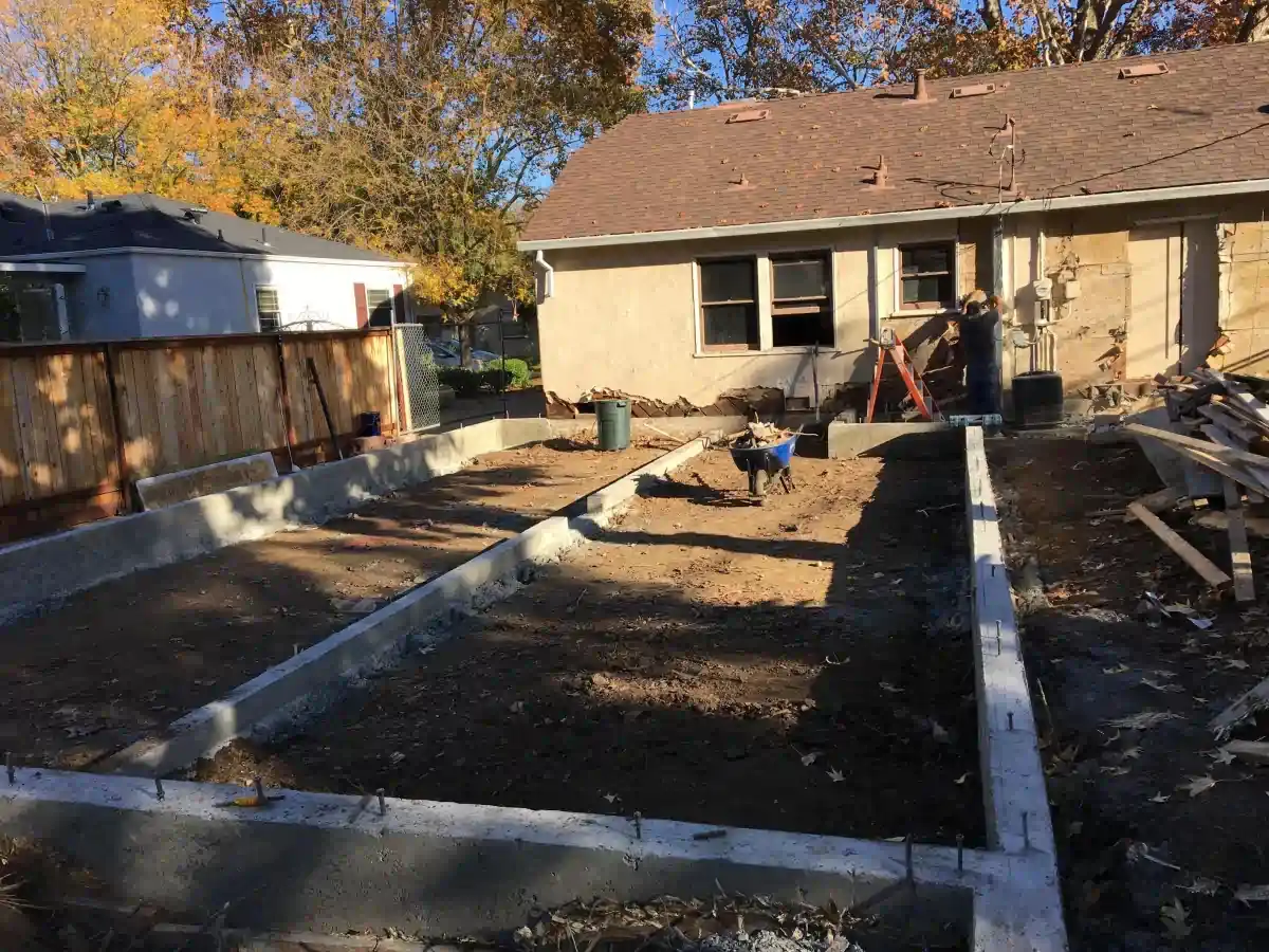 A house is being built with a lot of dirt in front of it.