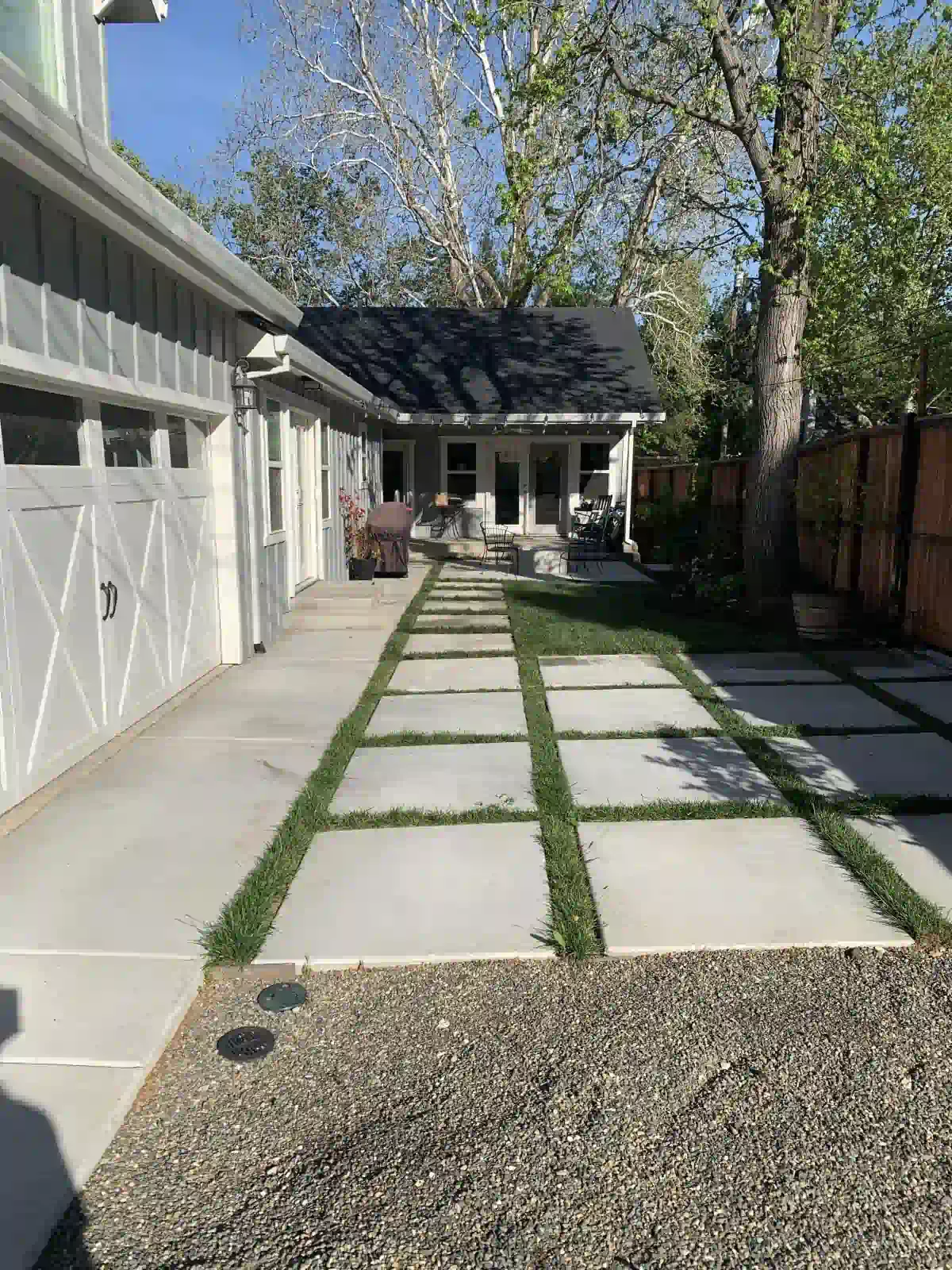 There is a concrete walkway leading to a house.