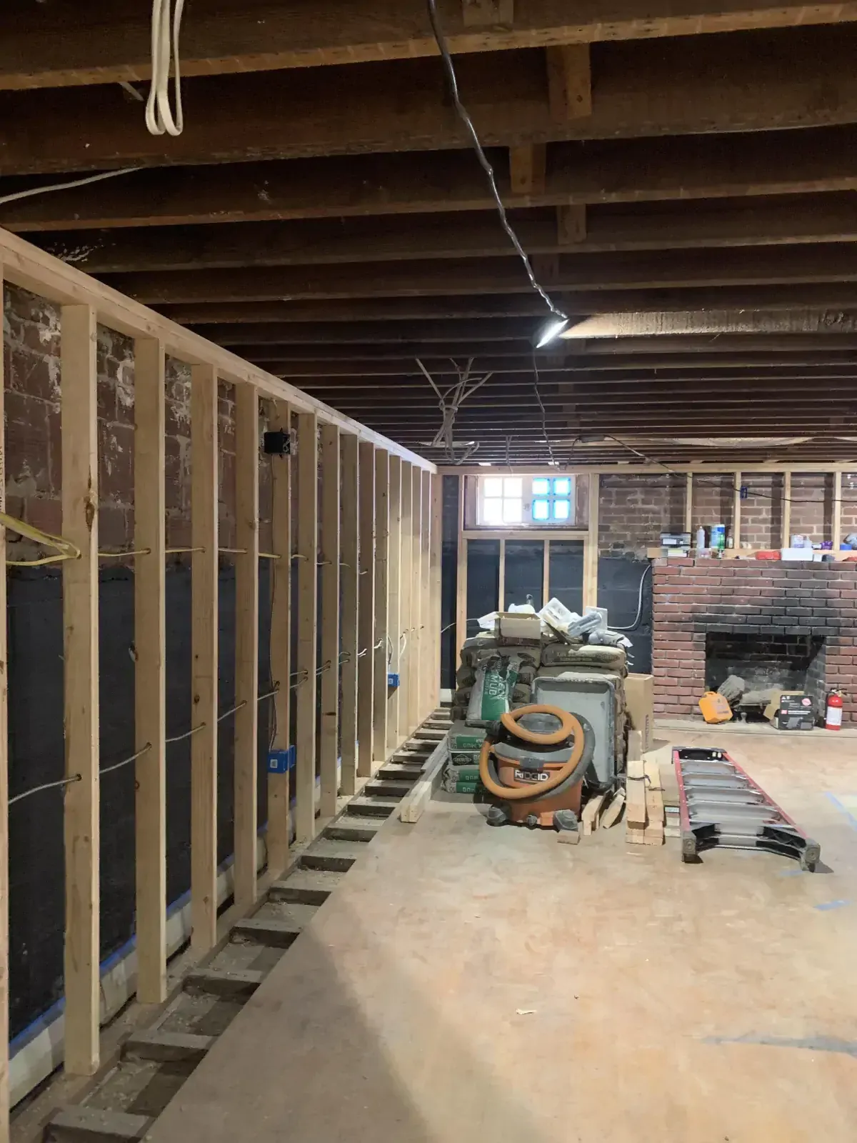 The inside of a building under construction with a brick fireplace.