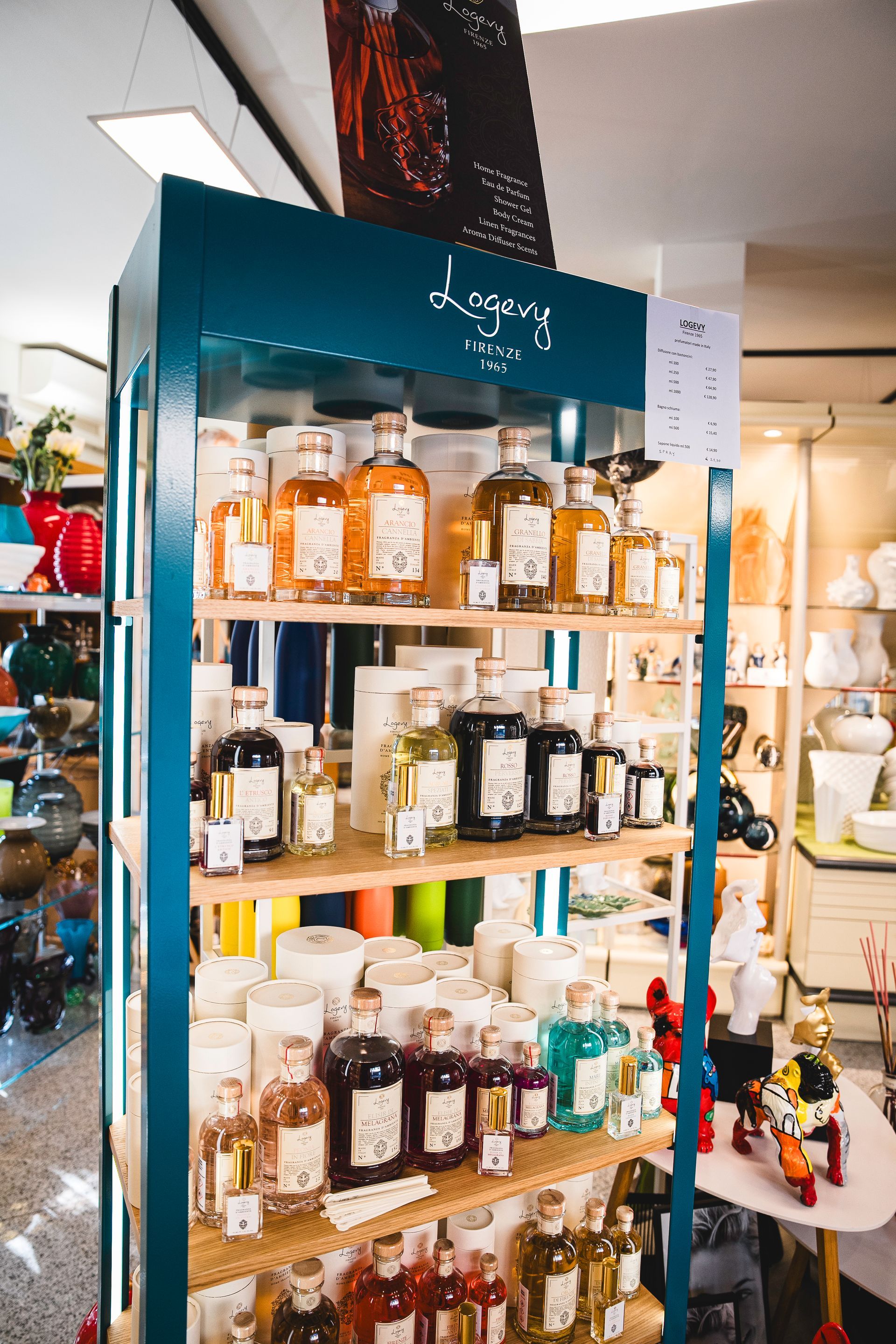 Un alto espositore color verde acqua contiene file di vari prodotti artigianali