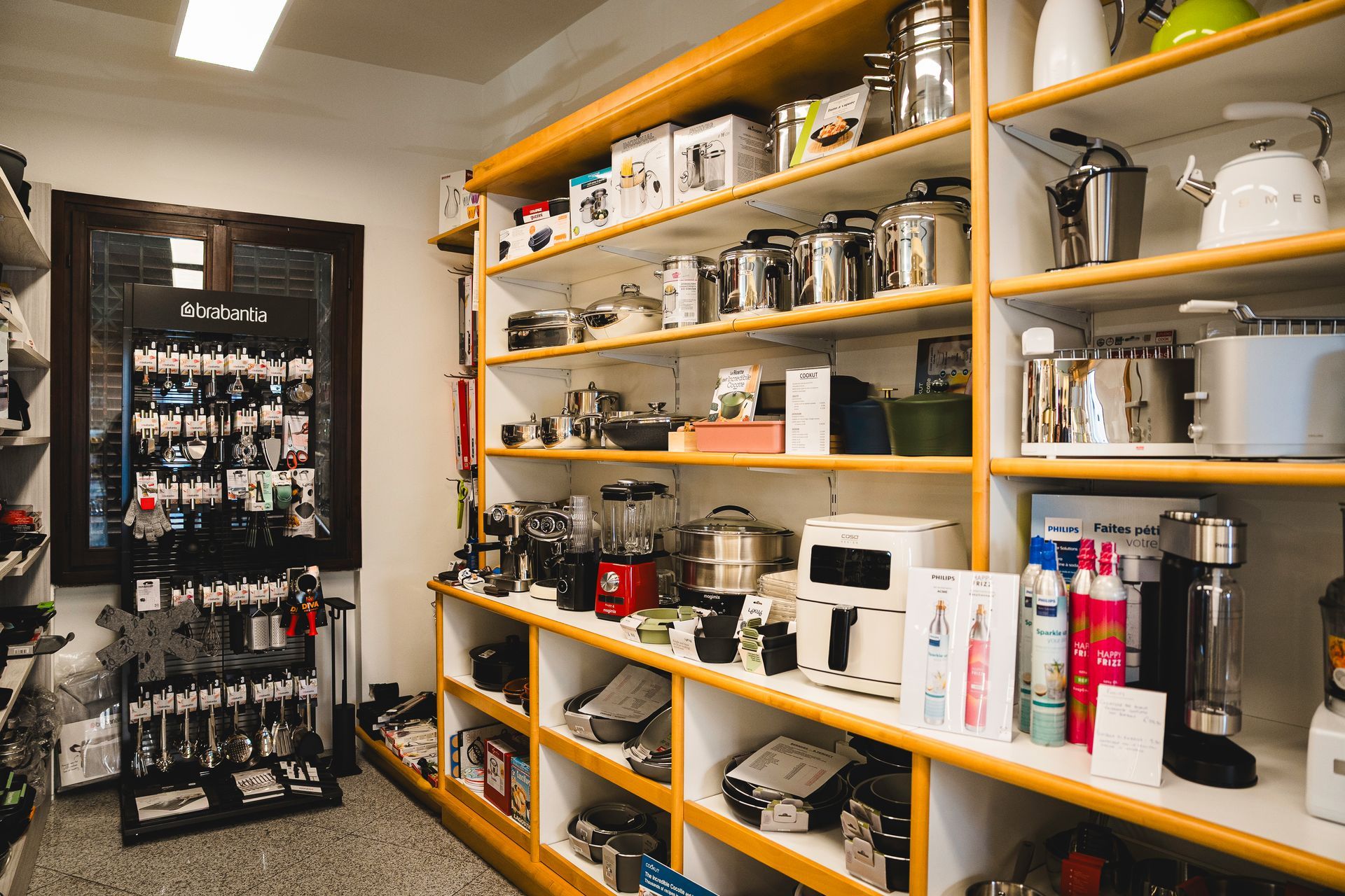 Uno scaffale di un negozio pieno di elettrodomestici da cucina
