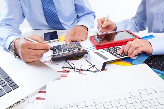 Several accountants make use of calculators to balance the books