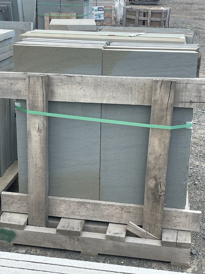 A wooden crate with a green rope around it