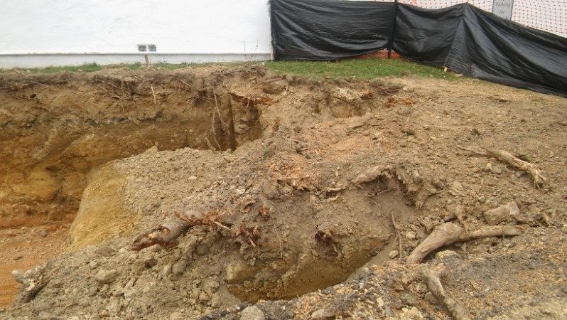 A large pile of dirt is sitting in front of a building.
