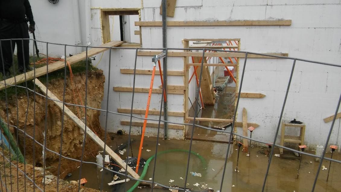 A construction site with a fence and a hole in the ground