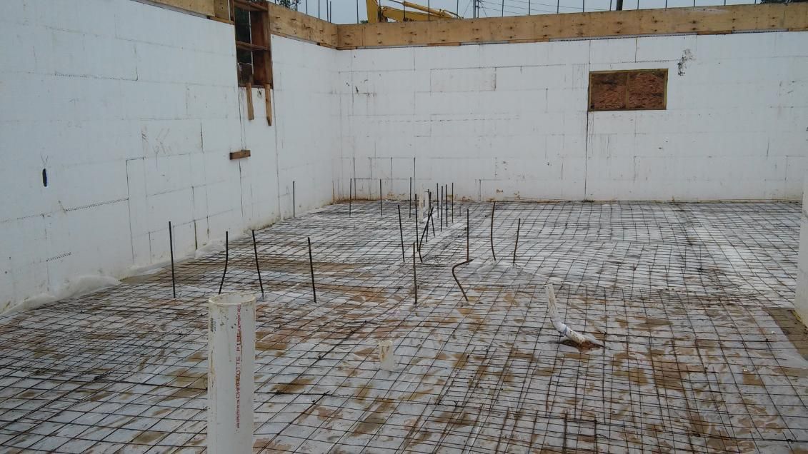 A building under construction with a concrete floor and walls.