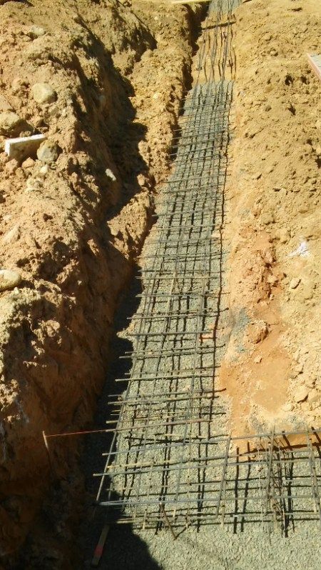 A trench filled with dirt and a row of metal bars.
