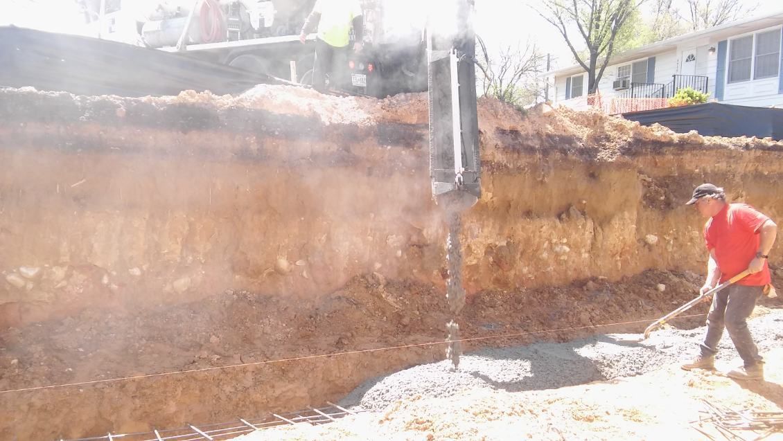 A man is digging a hole in the ground with a shovel.