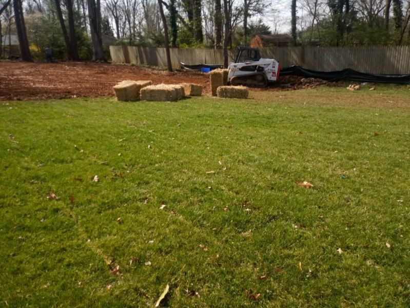 A bulldozer is sitting in the middle of a lush green field.