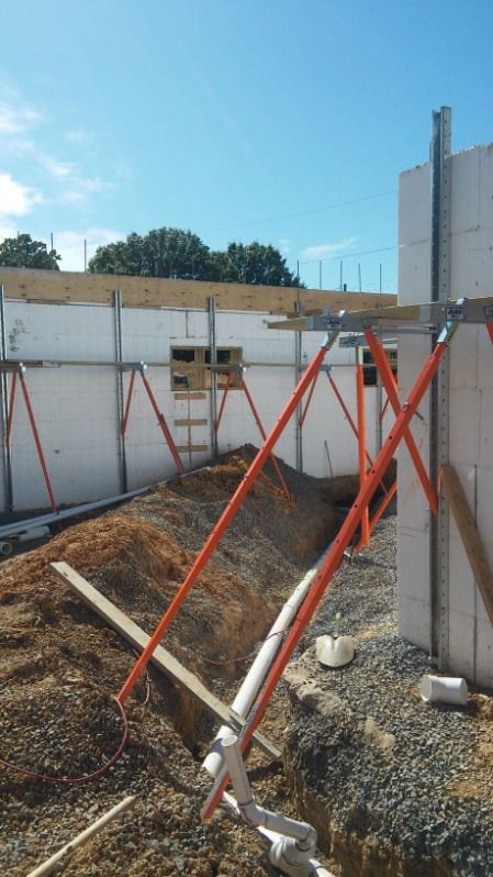 A construction site with a scaffolding and a pipe in the dirt.