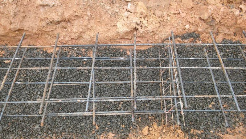 A metal grid is sitting on top of a pile of gravel.