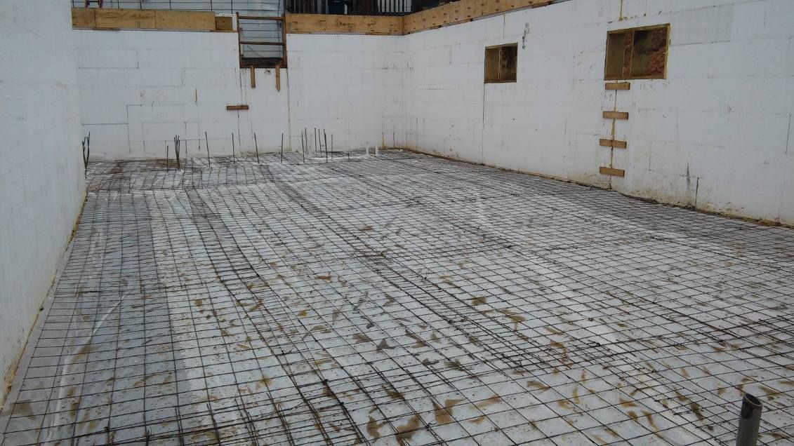 A building under construction with a concrete floor and walls.