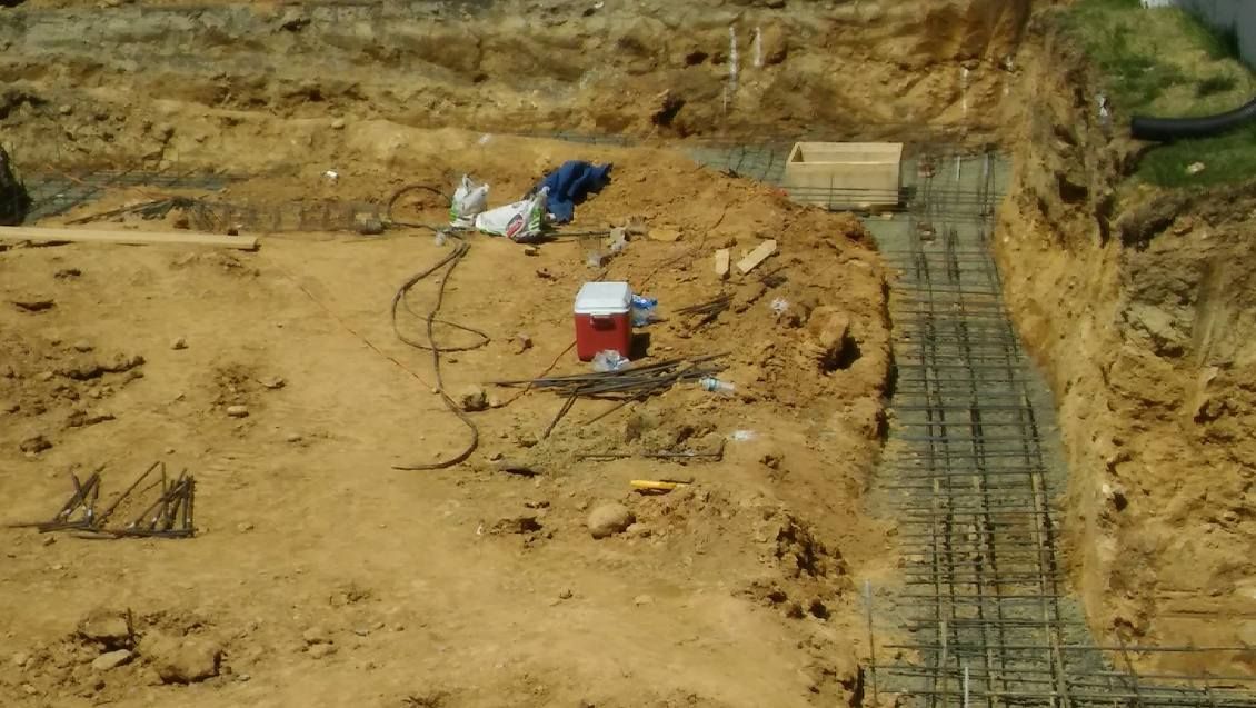 A red and white cooler is sitting in the middle of a dirt field.