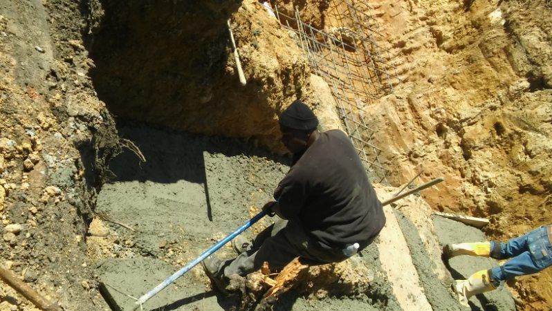 A man is digging a hole in the ground with a shovel.