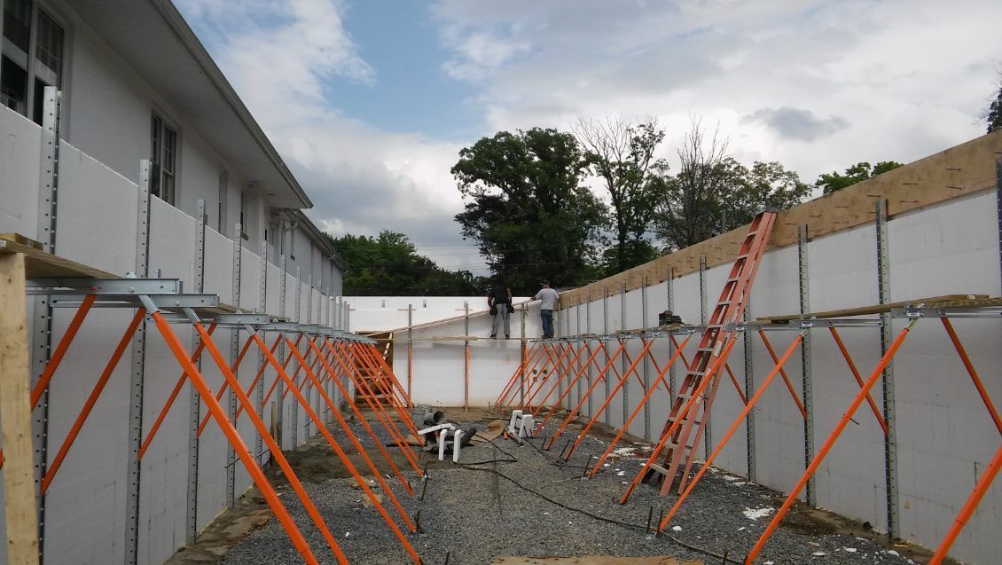 A building under construction with a ladder in the background.