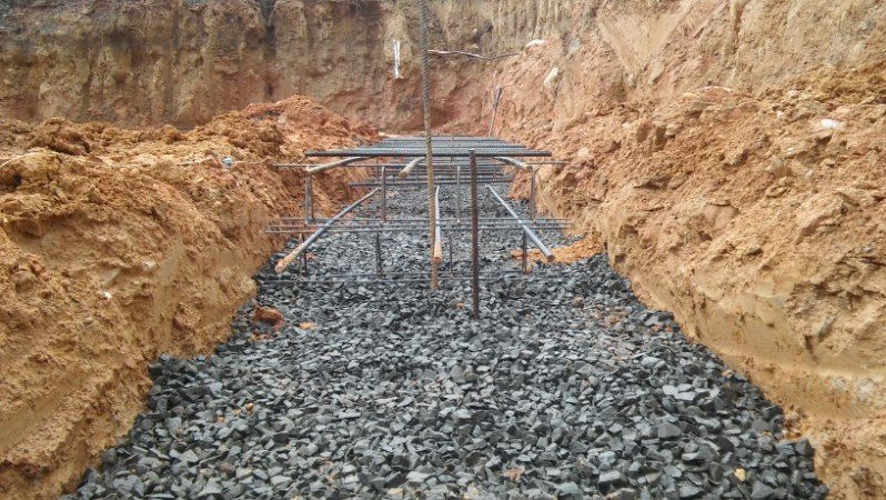 A trench filled with rocks and dirt with a metal structure in the middle.