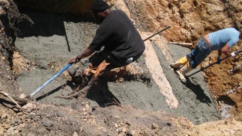 Two men are digging in the dirt with shovels