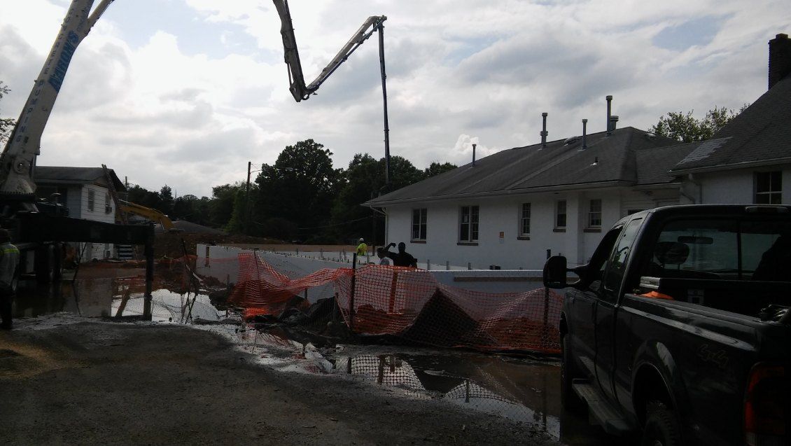 A truck is parked in front of a building under construction.