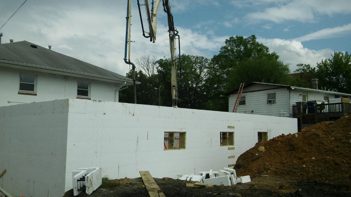 A concrete pump is being used to pour concrete into a building