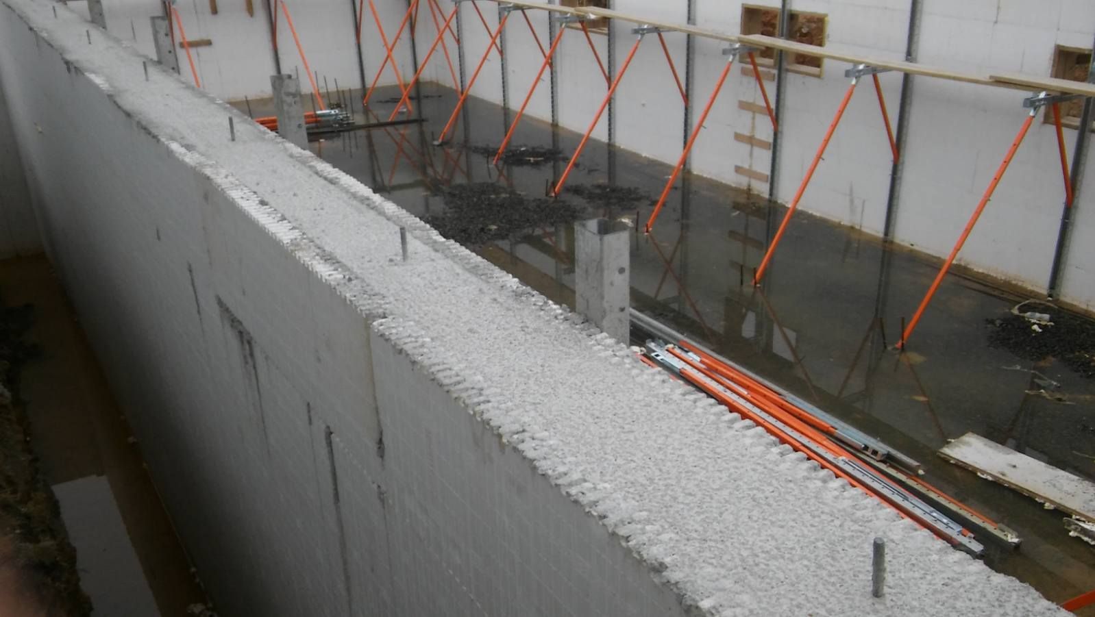 A concrete wall is being built in a building under construction.