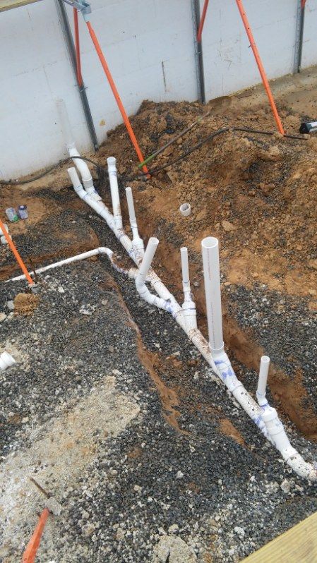 A bunch of pipes are being installed in the dirt.