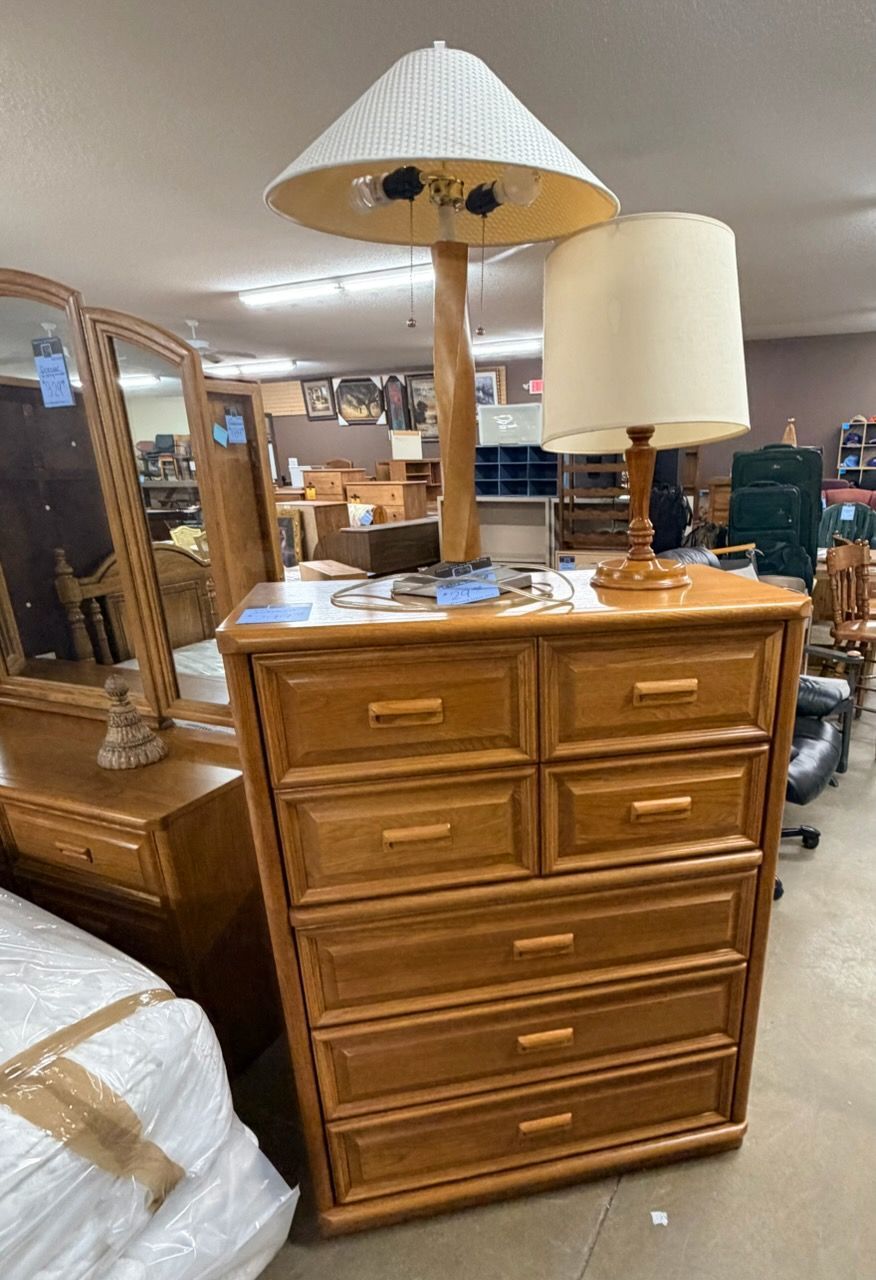 Bunk bed made of light-colored logs, with mattresses covered in plastic.