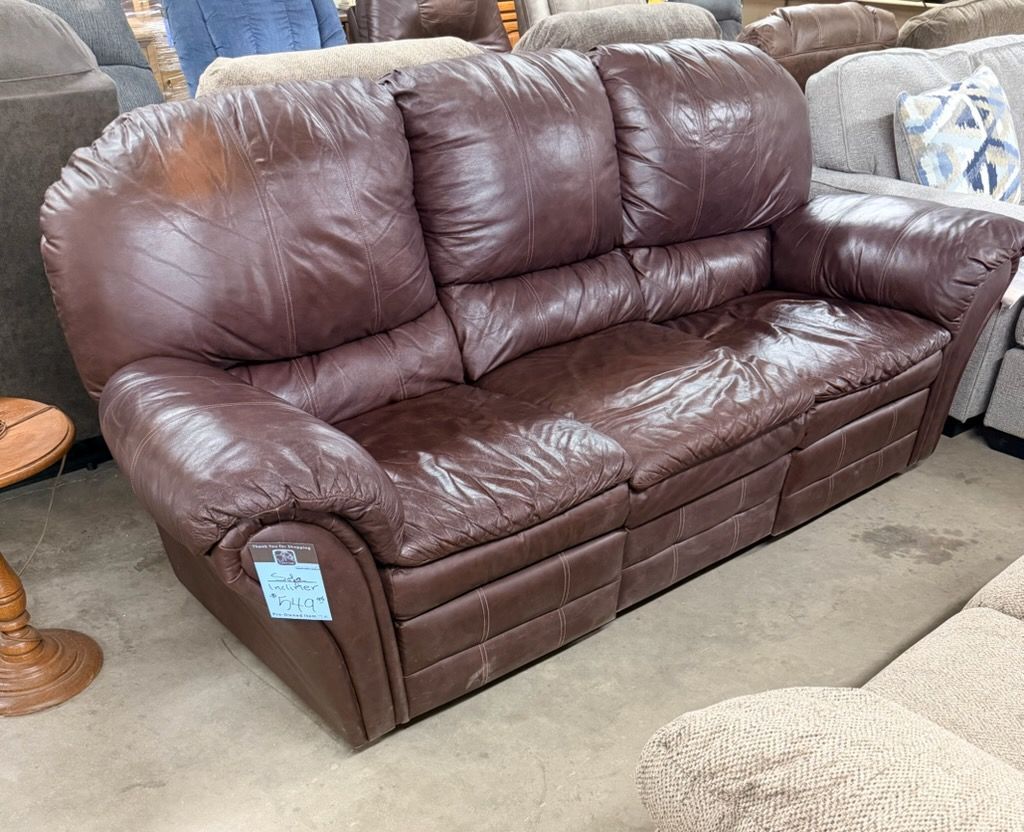Wooden TV stand with live edge details, and a rocking chair, in a store setting.