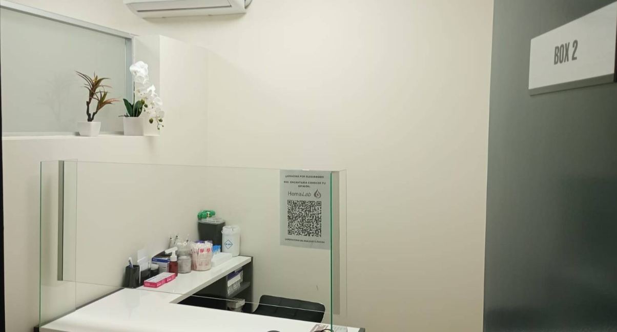 Una habitación con un escritorio, sillas, una computadora y un modelo de una columna vertebral.