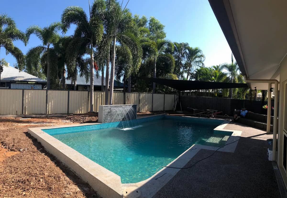 Swimming Pool in a Backyard, Blue Water, Waterfall Feature, Palm Trees, Sunny Day — Rod Hardy Plunge Pools in Girraween, NT