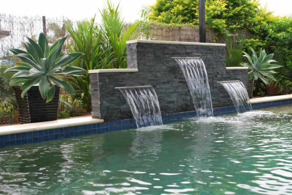 Water Cascading From a Dark Stone Wall Into a Swimming Pool — Rod Hardy Plunge Pools in Girraween, NT