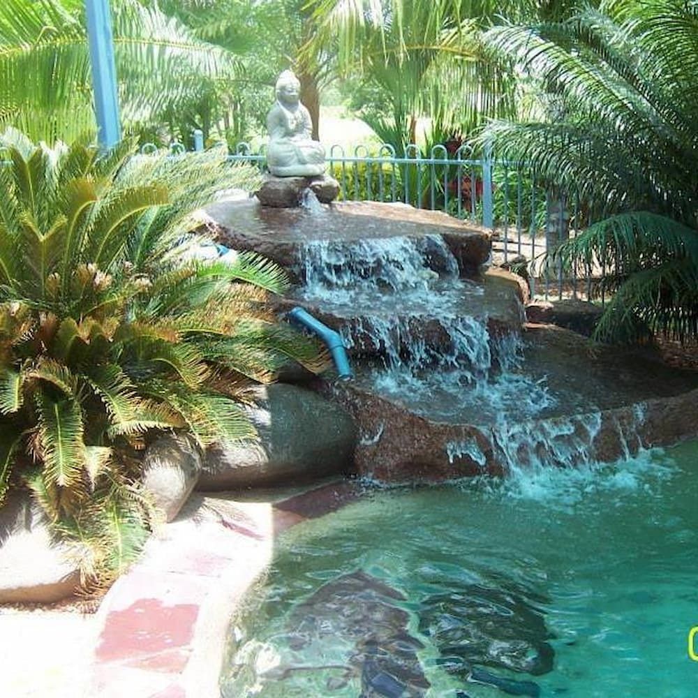 Waterfall Feature With a Statue, Flowing Into a Pool Surrounded by Greenery — Rod Hardy Plunge Pools in Girraween, NT