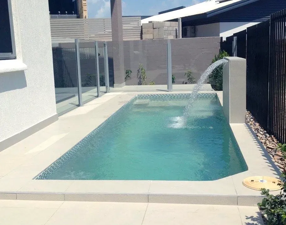 Waterfall Feature Cascading Into a Swimming Pool; Brown Rendered Fence — Rod Hardy Plunge Pools in Girraween, NT 