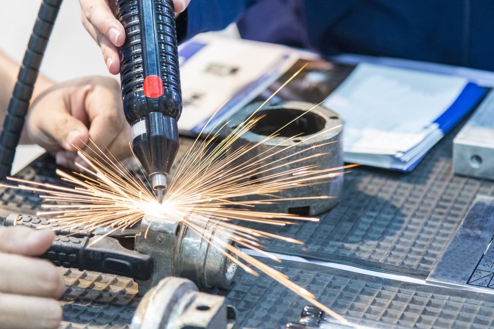 Hands welding metal, with bright sparks flying over a workbench and tools nearby
