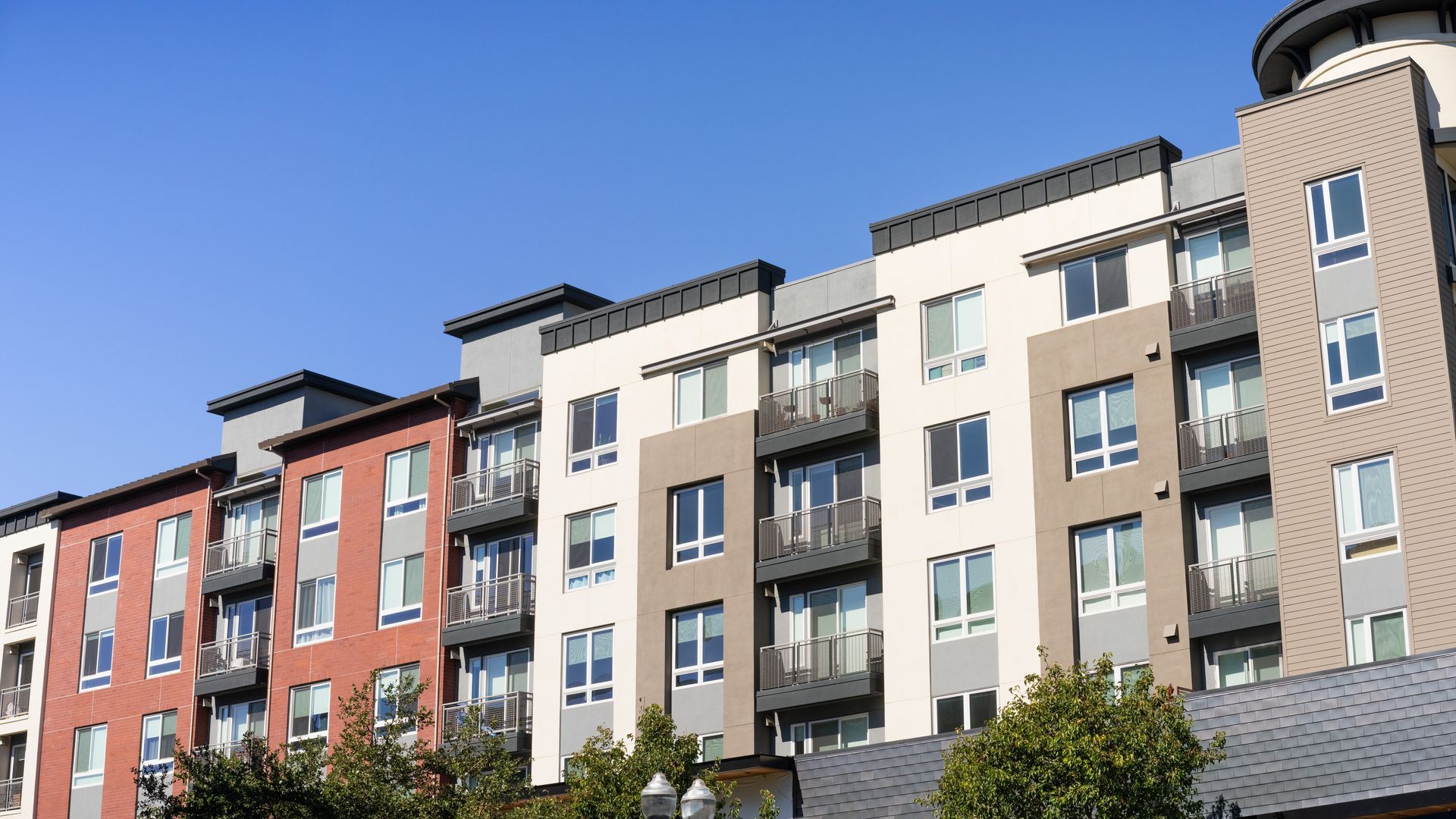 A row of apartment buildings with a blue sky in the background