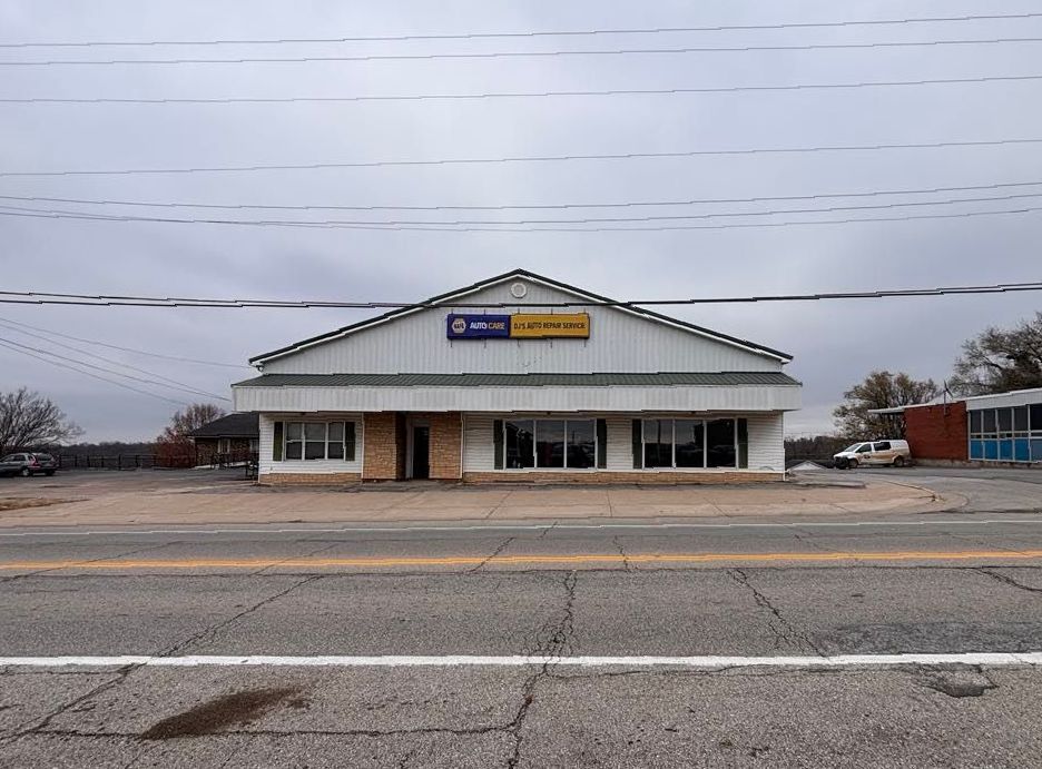 A large white building is sitting on the side of a road.