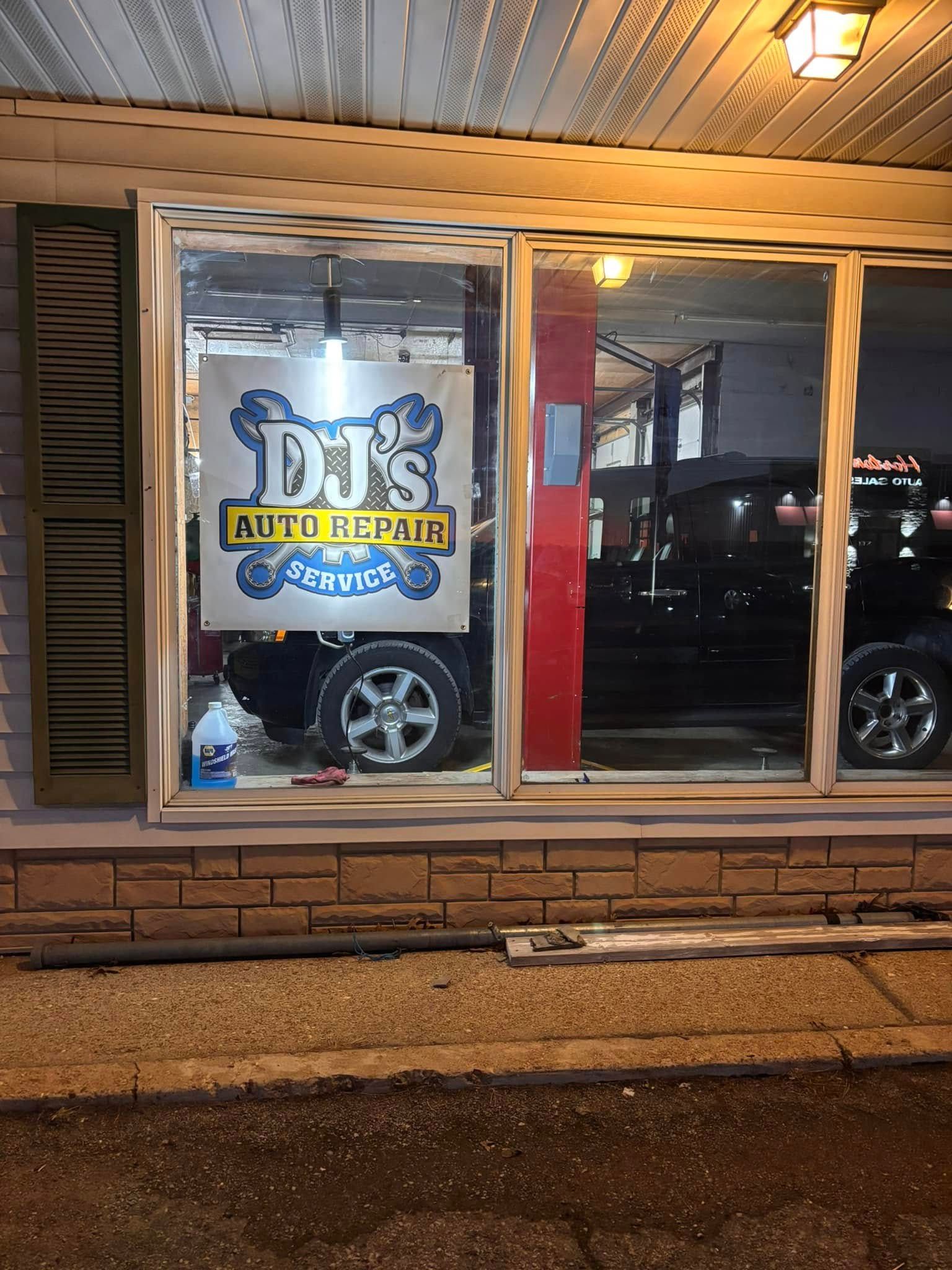 A window with a banner at DJ's Repair Service building in Linn, Missouri