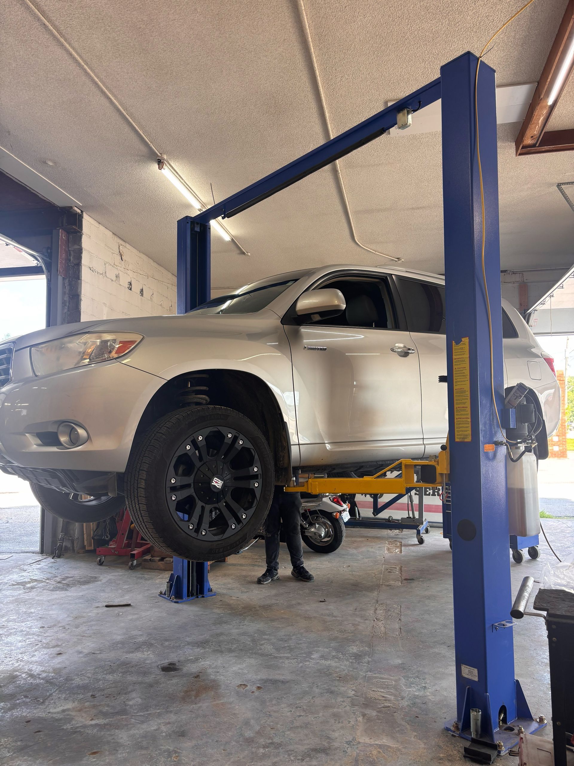 A car is sitting on a lift in a garage.