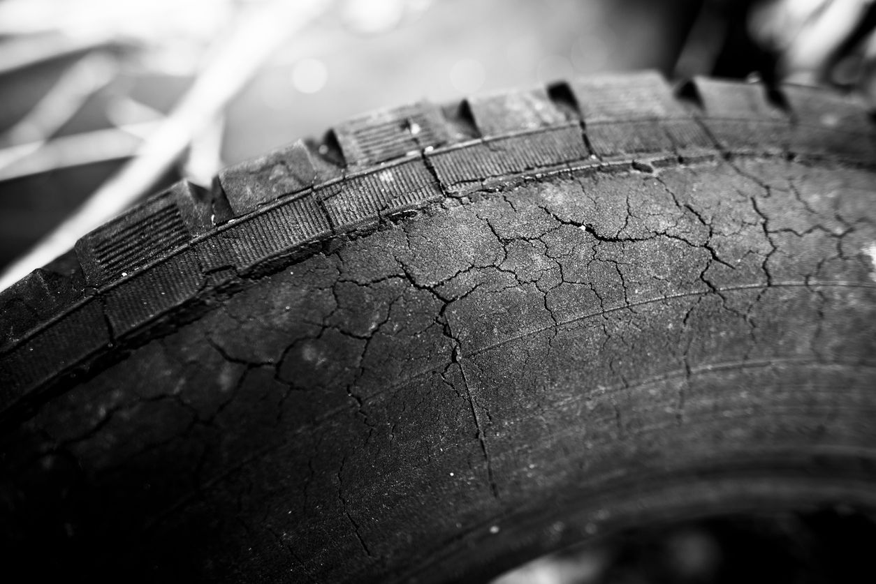 A close up of a cracked tire in a black and white photo.