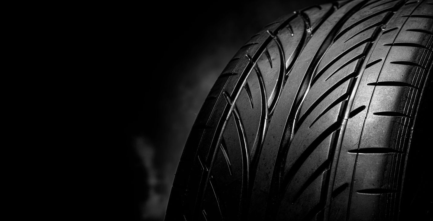 A close up of a car tire on a black background.