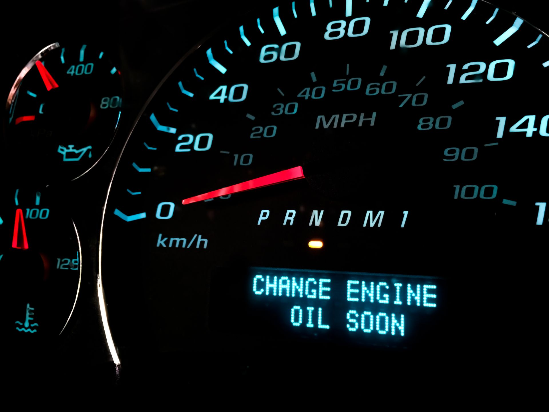 A close up of a speedometer that says change engine oil soon