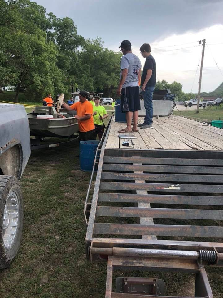 A group of men are standing on top of a trailer.