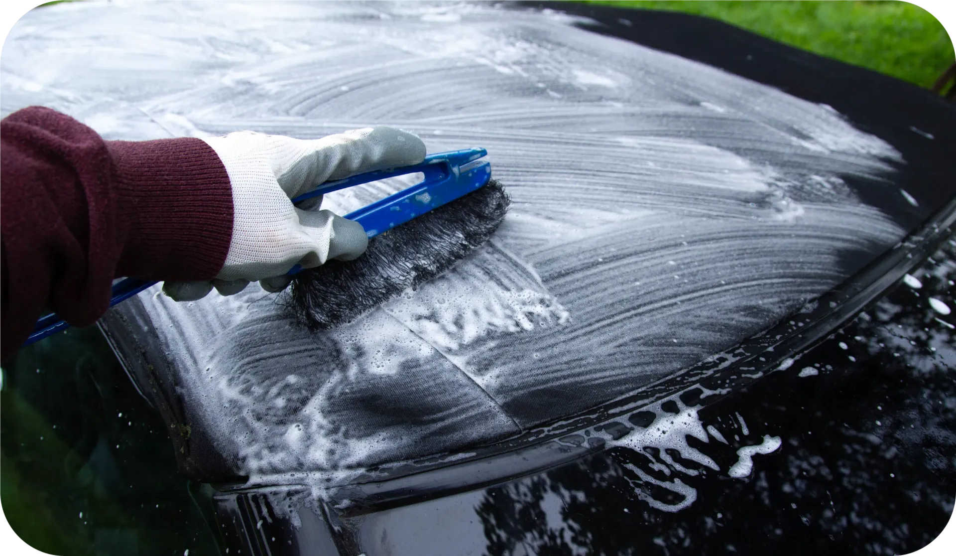 Black convertible car's roof from above, with interior visible through the windshield.