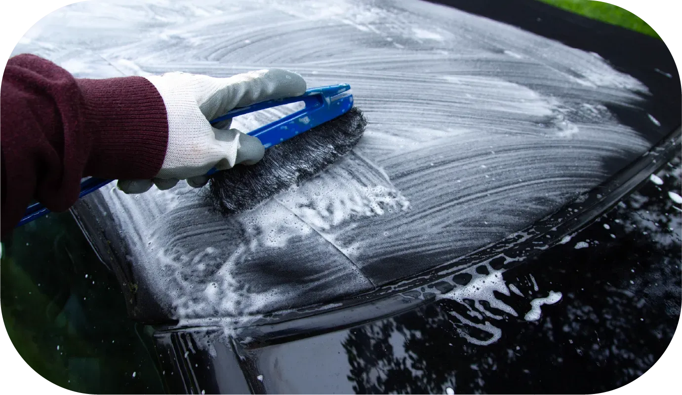 Black convertible car's roof from above, with interior visible through the windshield.