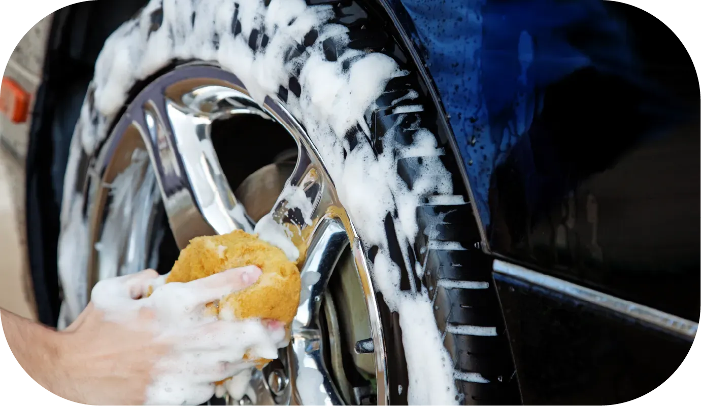 Ferrari logo on blue car covered in suds.