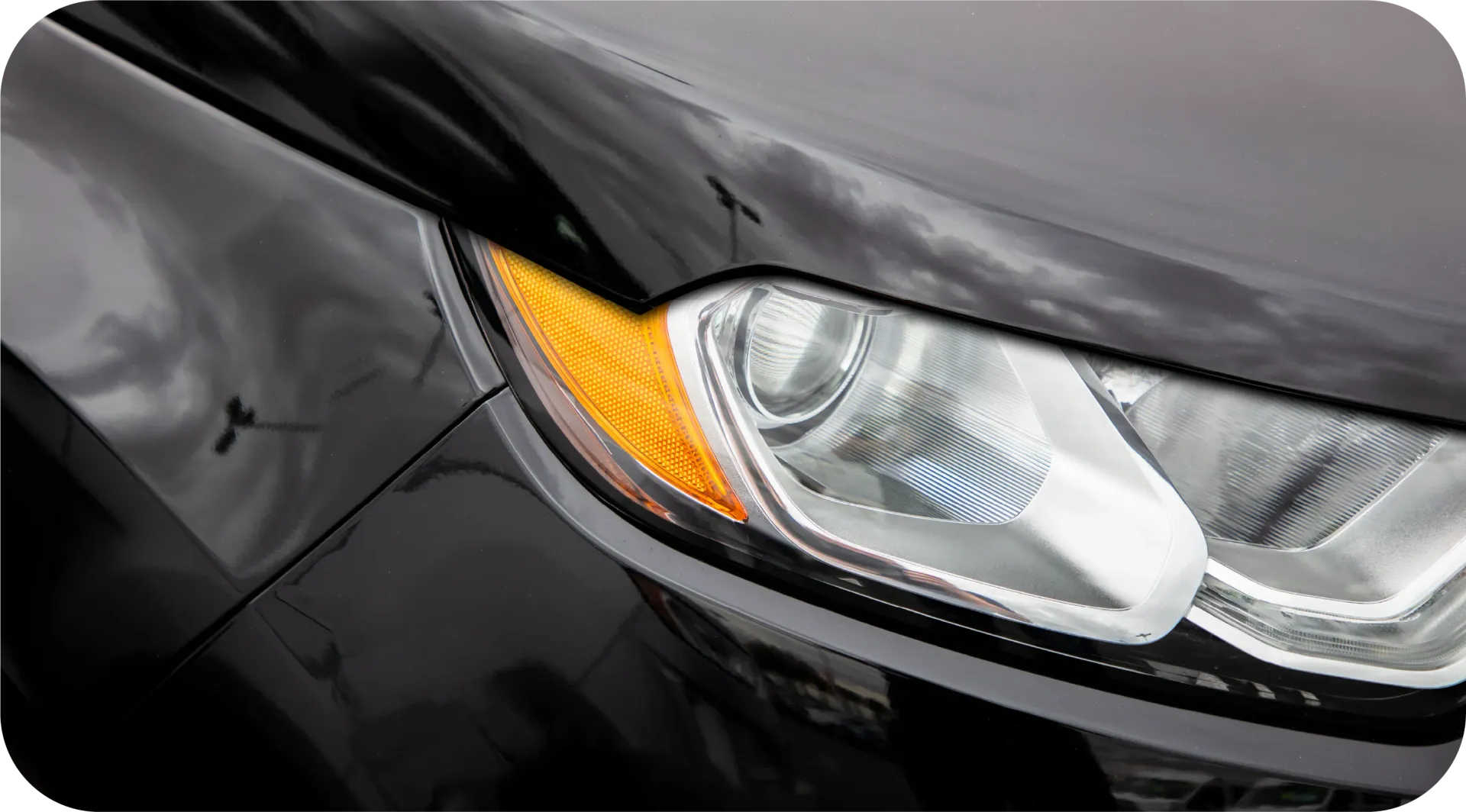 Black McLaren sports car parked outdoors, front view.