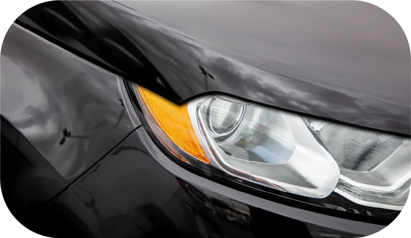 Black McLaren sports car parked on a street in front of a building.