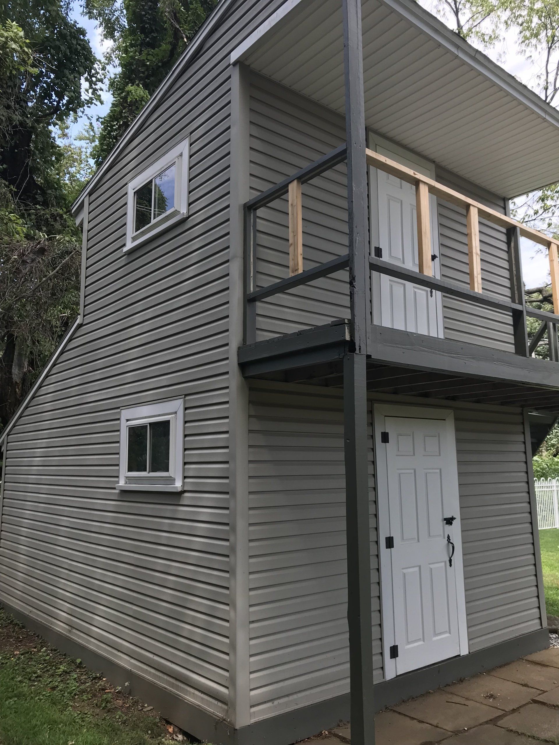 A gray house with a balcony on the second floor