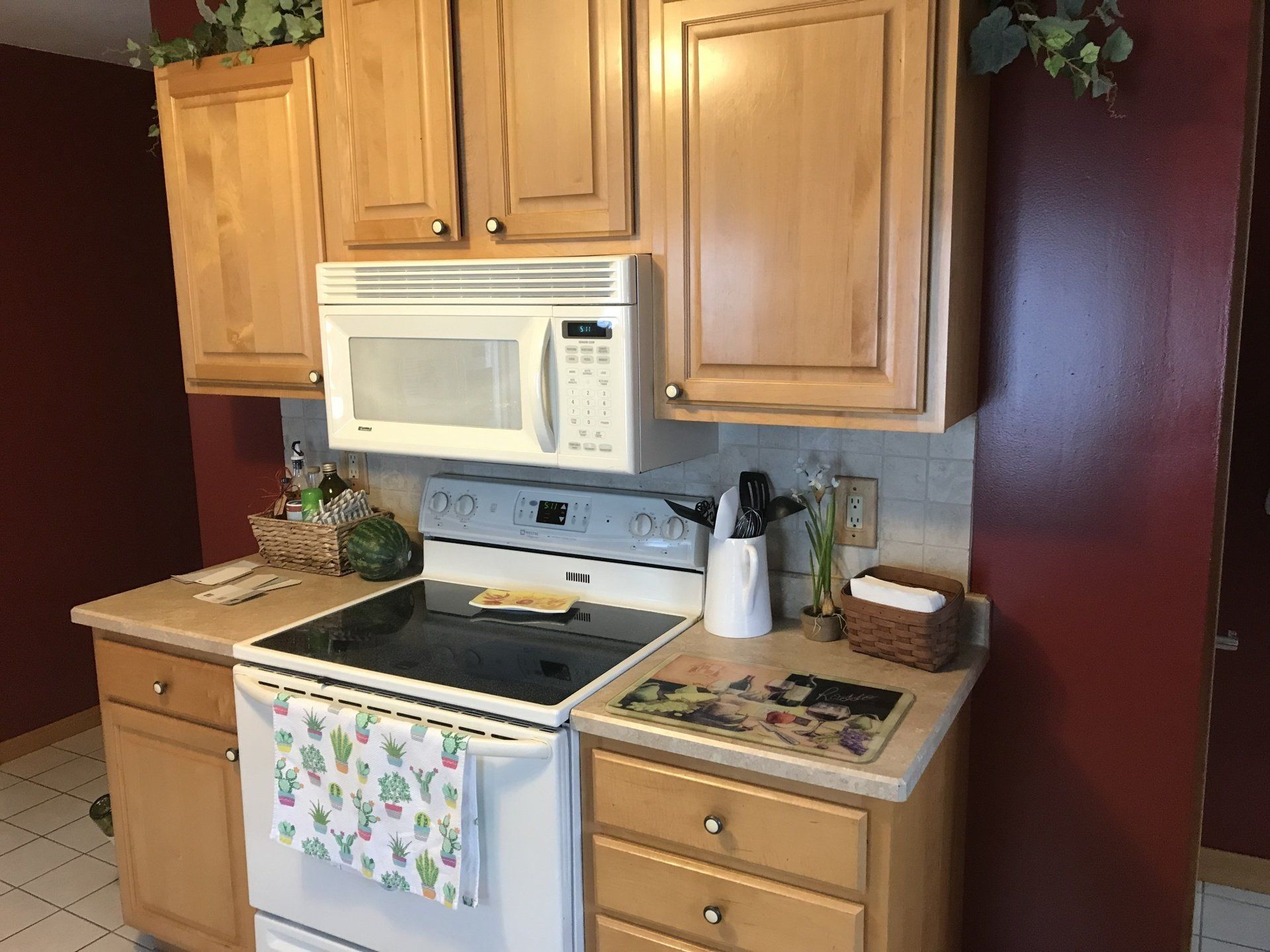 A kitchen with a stove , microwave and cabinets
