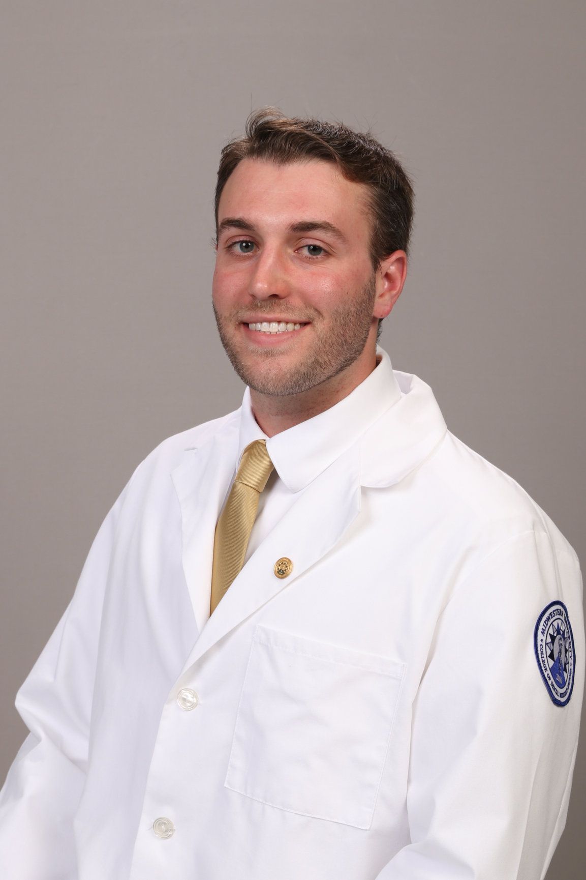 A woman is smiling while sitting in the back seat of a car.